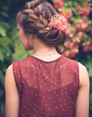 Rear view of woman with red flowers in her updo